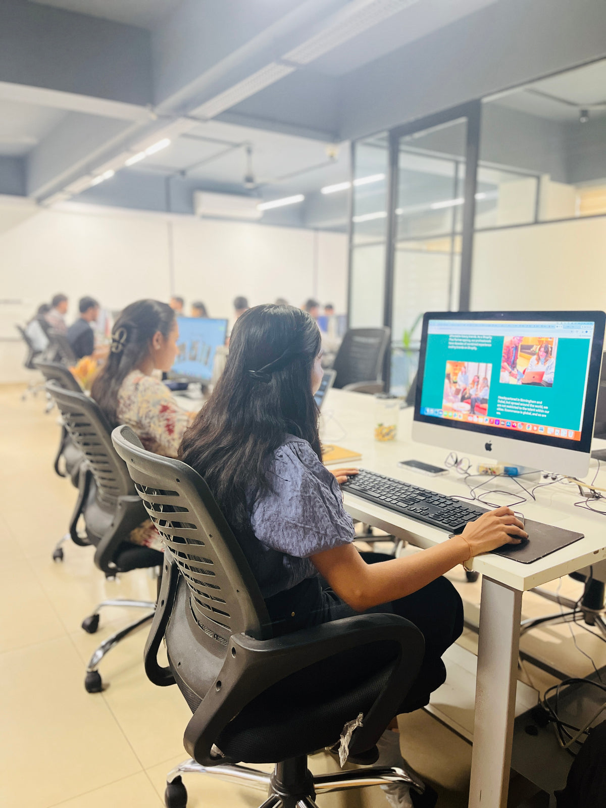 Ambiw team members working at their desktop computers in the Shopify development studio.