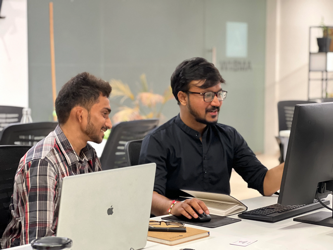 Shopify developers working together to review code and web design mockups at the Ambiw office.