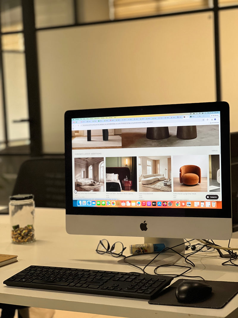 Close-up of an iMac desktop computer displaying a premium e-commerce furniture store interface design