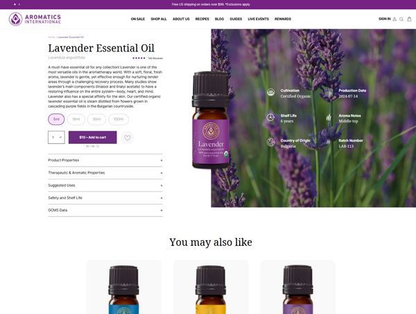 Desktop product page for Aromatics International's Lavender Essential Oil, featuring key specifications next to an image of the amber bottle overlaid on blooming lavender.
