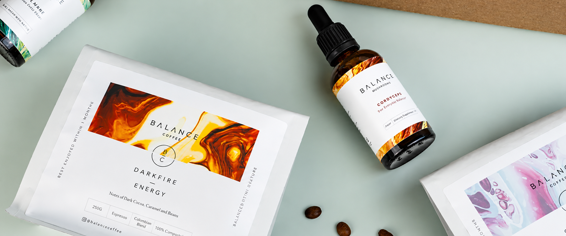 A flat lay of Balance Coffee "Darkfire Energy" bags alongside a Balance Mushrooms "Cordyceps" liquid dropper
