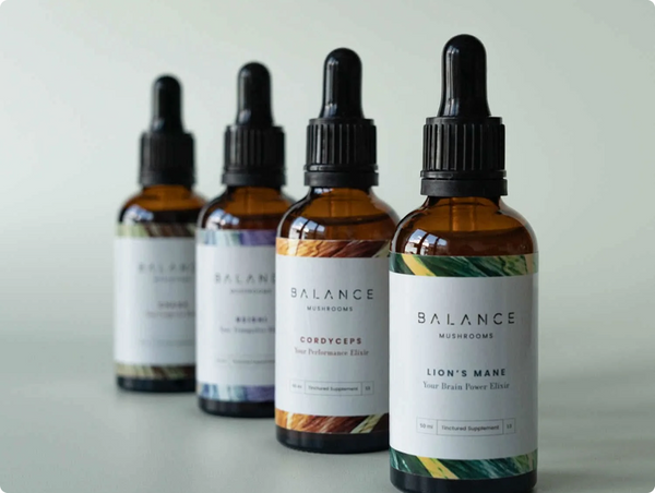 A clean, diagonal lineup of Balance Mushrooms amber dropper bottles, spotlighting their Cordyceps and Lion's Mane liquid tinctures.