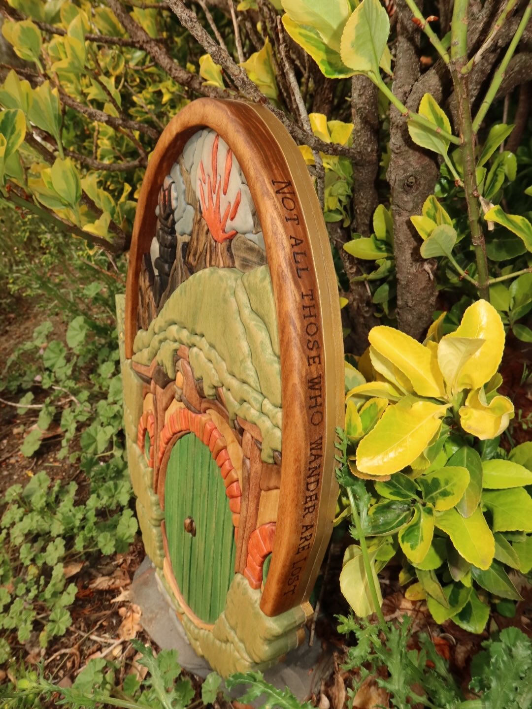 A carved wooden art piece of a hobbit door in a garden, sold by Bearwood in Langley, BC, whose Magento to Shopify migration was managed by Ambiw.