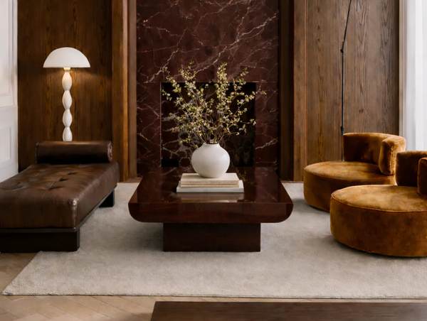 A luxury living room layout with a brown leather daybed, two velvet armchairs, and a glossy coffee table from the Forom online store lookbook.