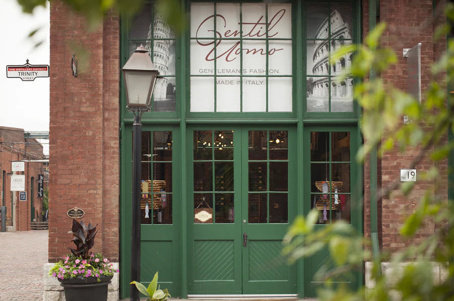 The brick storefront and green doors of the Gentiluomo boutique in Toronto, whose WordPress to Shopify migration was handled by Ambiw.