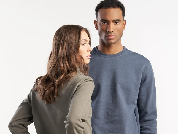 A close-up studio photograph of two models showcasing sustainable crewneck sweatshirts of Jerico