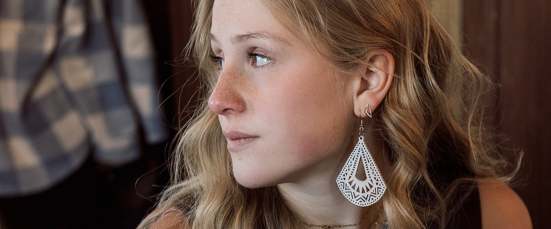 Close-up of a woman wearing a silver earring with a blurred background